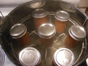 apple butter in jars ready for boiling bath